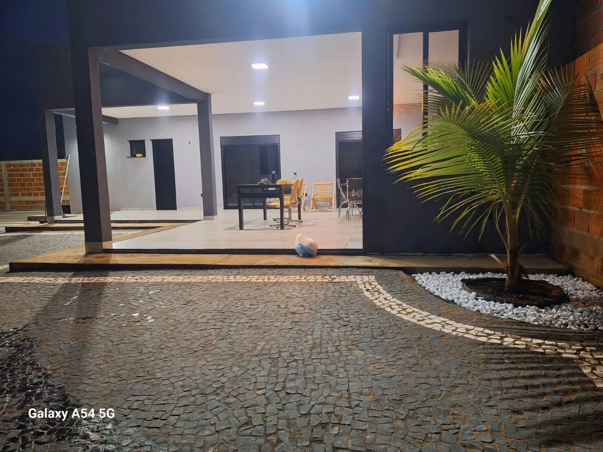 Fachada da casa de campo com varanda gourmet à noite