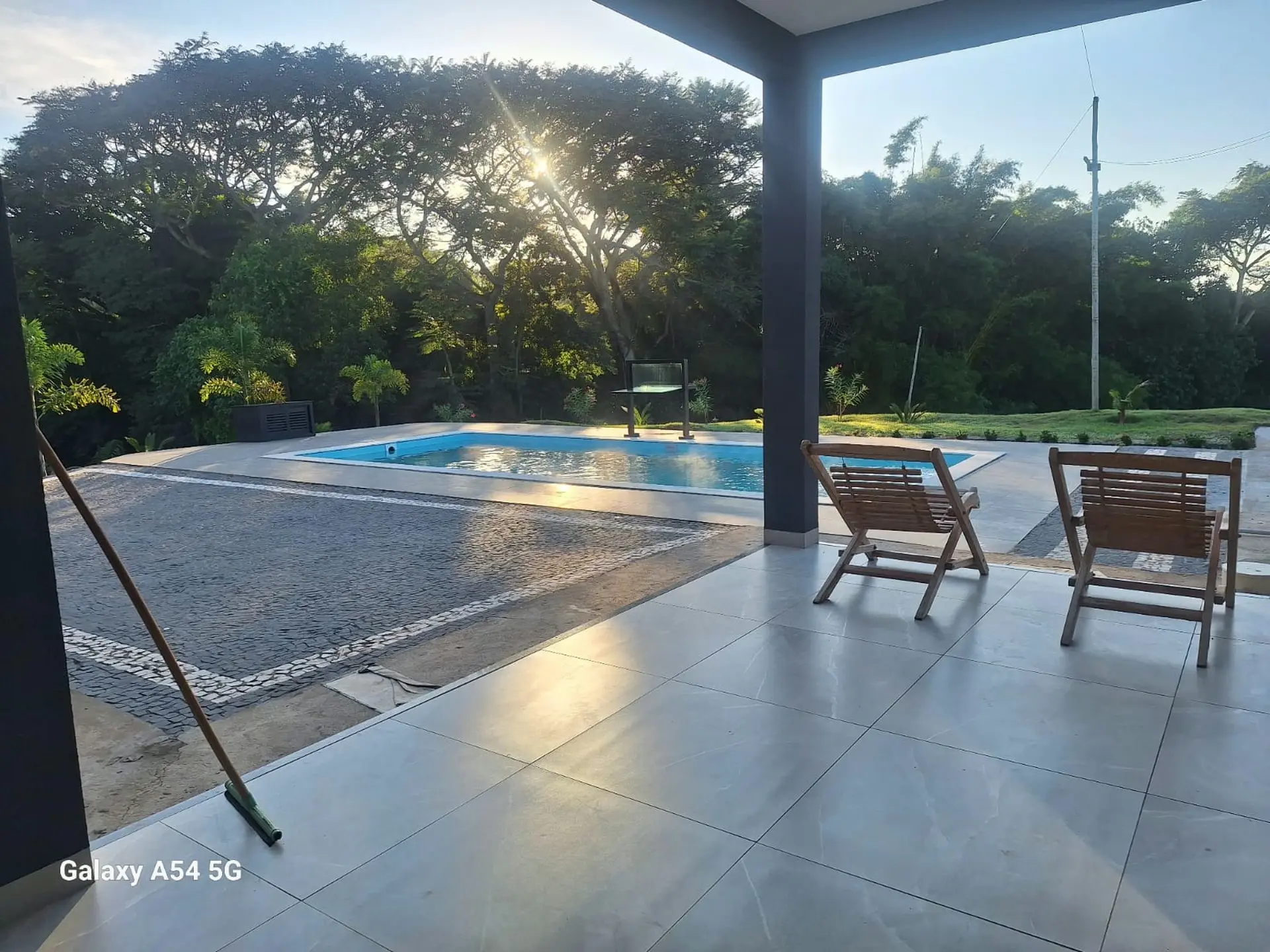 Varanda com vista para a piscina da chácara ao amanhecer
